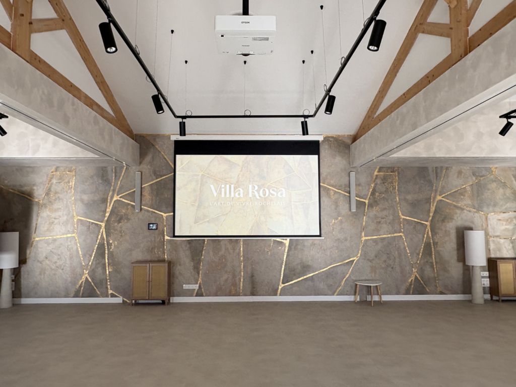 Réalisation Tedelec à la Villa Rosa : Équipement audiovisuel sur mesure comprenant un vidéoprojecteur Epson blanc discret et un système d'éclairage sur rails, respectant l'architecture singulière du pôle événementiel.