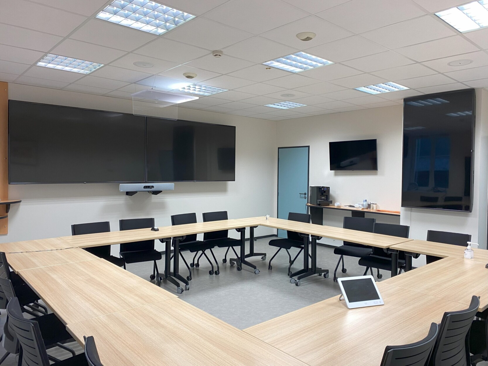 Salle de direction et contrôle Salle de réunion entièrement équipée par TEDELEC : cet espace modulaire a été conçu pour répondre aux nouveaux usages collaboratifs, en présentiel comme à distance. Il comprend : Deux écrans 86” 4K muraux en affichage étendu, permettant la diffusion simultanée de contenus (partage de documents, visioconférence, etc.). Une barre de visioconférence tout-en-un (type Poly Studio ou Yealink MeetingBar), intégrant caméra 4K auto-cadrante, micro longue portée et haut-parleurs intégrés. Un système de pilotage tactile centralisé (écran tactile Crestron ou Cisco Touch) offrant un contrôle simplifié des sources, de l'audio, de la visioconférence et du lancement de réunions Microsoft Teams ou Zoom. Écrans secondaires 55” en appoint, permettant une meilleure lisibilité pour tous les participants dans les grands formats en U ou en L. Mobilier mobile et pliant (tables et chaises sur roulettes) facilitant la reconfiguration de l’espace en quelques minutes : réunion, atelier, formation ou comité. Connectique centralisée intégrée dans la table (HDMI, USB-C, alimentation), avec possibilité de partage sans fil via un système comme ClickShare ou Miracast. Gestion acoustique optimisée par des plafonniers absorbants et un positionnement stratégique du matériel de captation. Distribution réseau sécurisée via un mini-rack technique dissimulé, assurant la stabilité des flux audiovisuels et de la connectivité. Éclairage LED intégré au faux plafond, assurant un rendu vidéo optimal sans éblouissement ni zones d’ombre. Cette salle permet d'assurer des réunions fluides, confortables et inclusives, dans un environnement technique de haut niveau, parfaitement adapté aux exigences des environnements professionnels modernes.