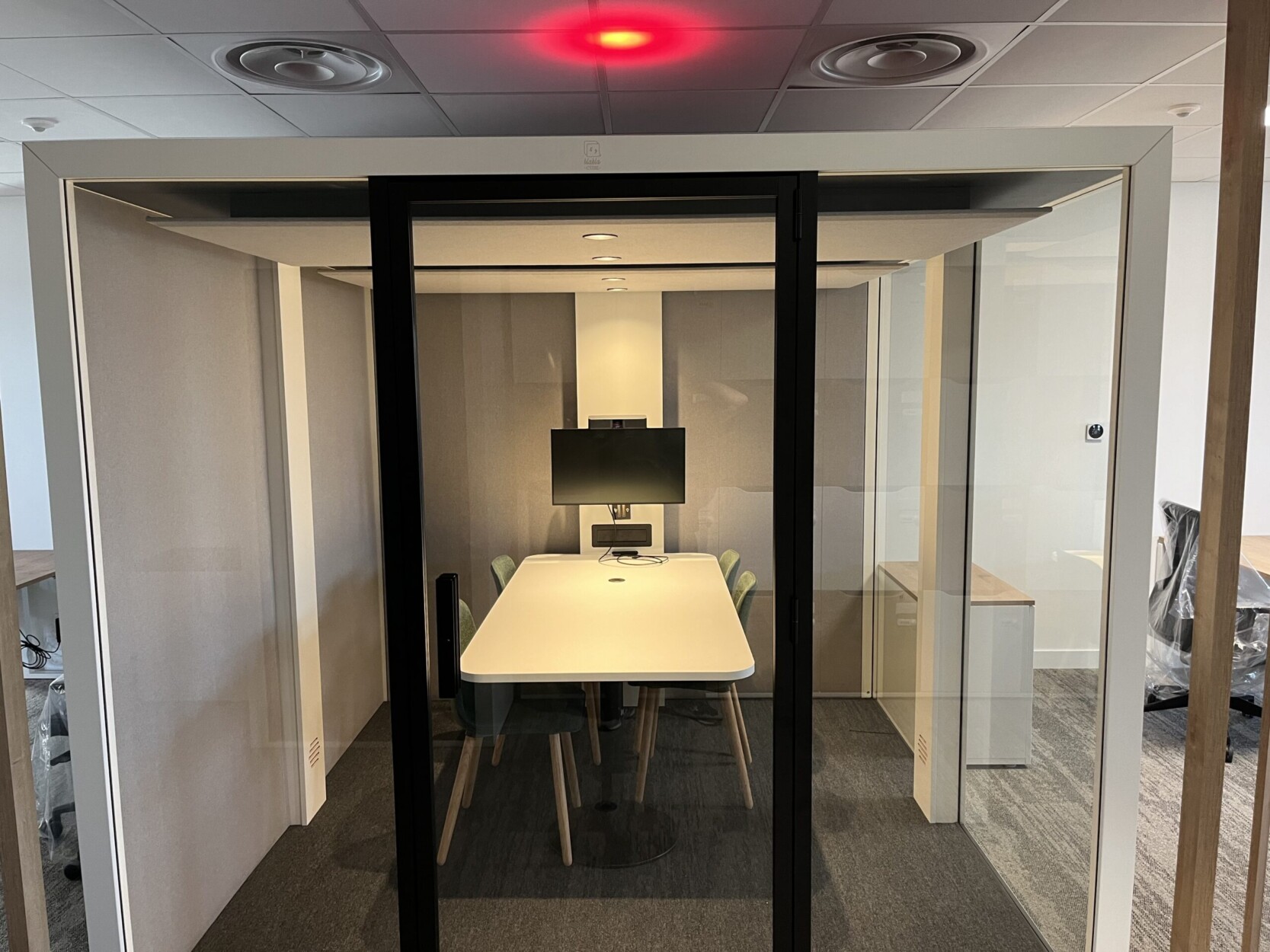 Huddle Room équipée par TEDELEC : écran mural, barre de visioconférence tout-en-un et connectique simplifiée, intégrés dans une cabine acoustique autonome. Compatible Microsoft Teams Room, cette solution favorise la concentration et les échanges en petit comité, sans nuisance sonore pour l’open space.