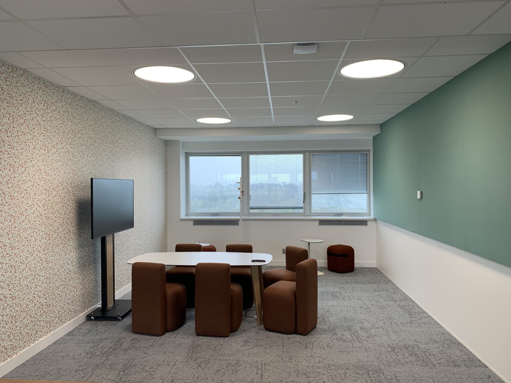 Espace de travail collaboratif équipé par TEDELEC : écran mobile 4K sur support motorisé, connectique intégrée et mobilier compact pour petits comités. Une configuration pensée pour les échanges rapides, les réunions Teams et le travail en mode agile, dans un cadre confortable et chaleureux.